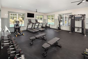 A spacious gym with treadmills, elliptical machines, and weightlifting equipment.